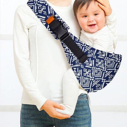 Porte bebe bandoulière bleu à motifs avec bébé porté sur la hanche