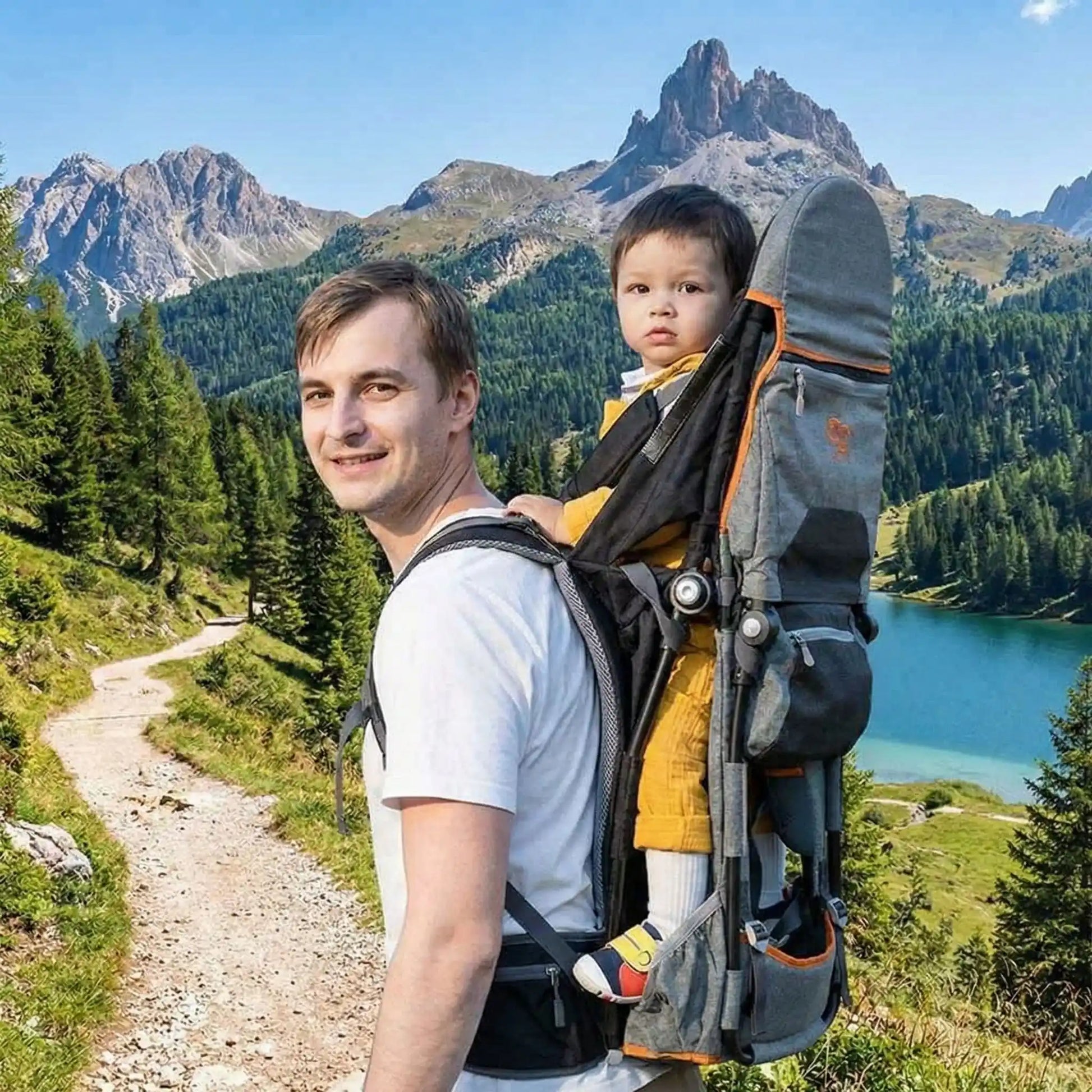 Porte-bébé de randonnée Ultra Confort gris et orange utilisé en montagne avec vue sur lac