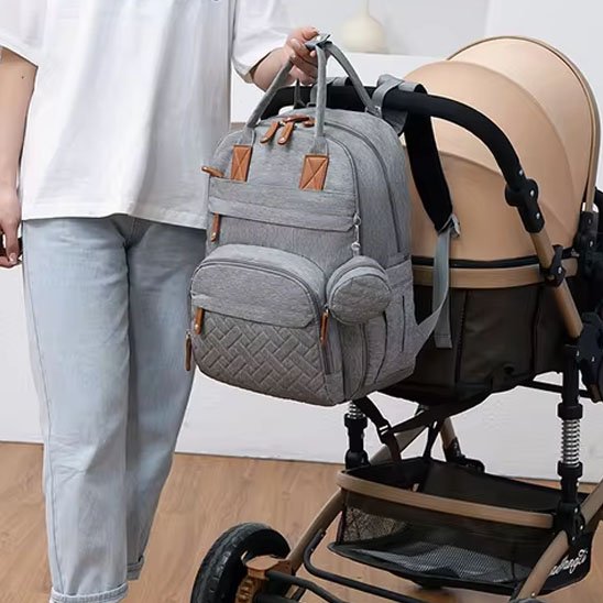 Sac à dos à langer accroché à une poussette bebe.