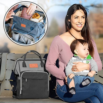 Parent assis avec bébé et sac à dos à langer à côté.