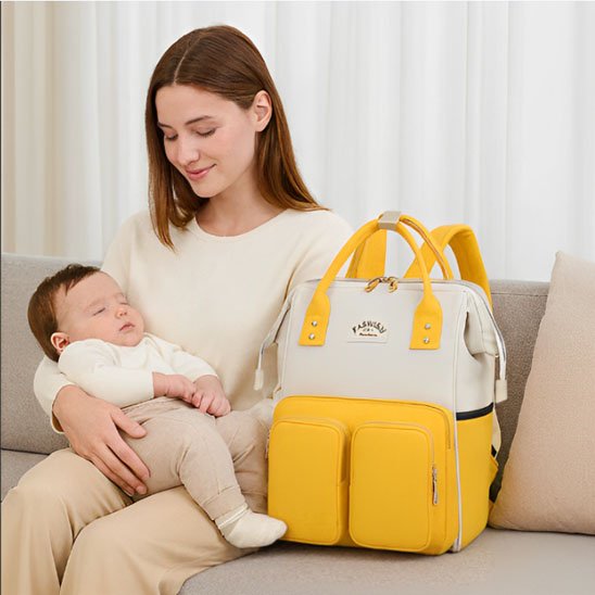 Sac à dos à langer jaune et beige avec accessoires pour bebe.