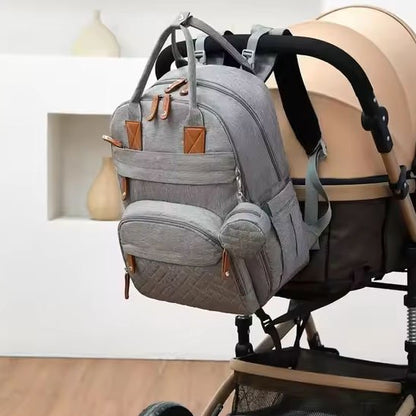 Sac à langer elegant gris, suspendu à une poussette beige