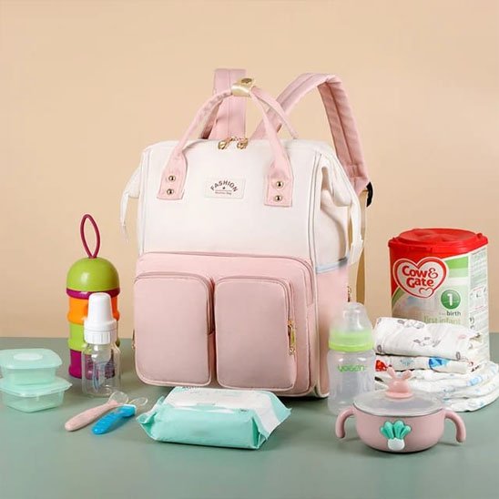 Sac à dos à langer rose et beige avec accessoires pour bebe.