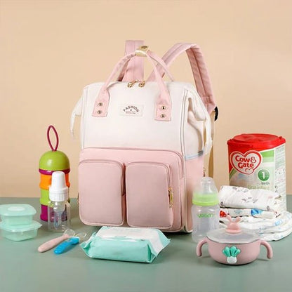 Sac à dos à langer rose et beige avec accessoires pour bebe.