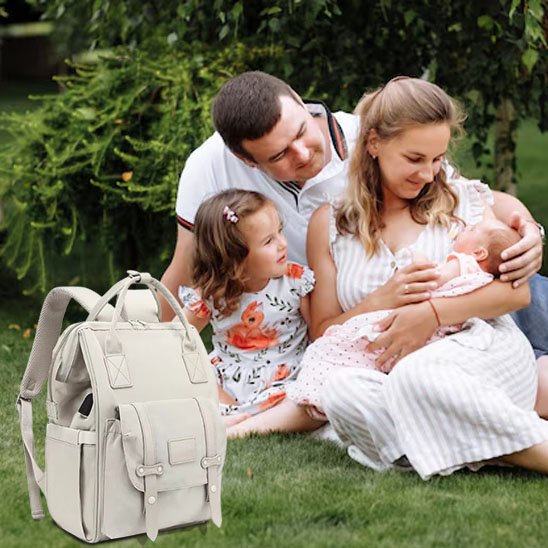 Sac a langer gris clair porté par maman en extérieur