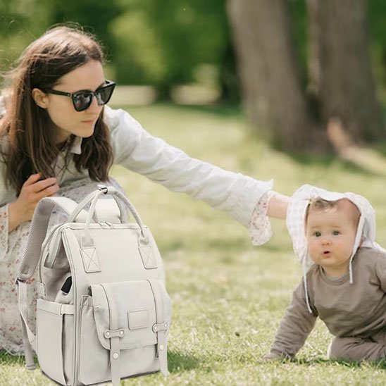 Sac a langer gris clair porte par maman en extérieur